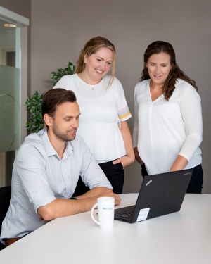 Valiansatte rundt en PC